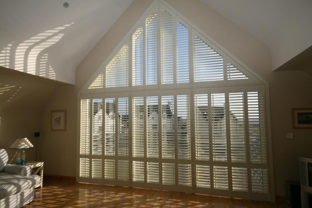 Custom plantation shutters fitted to a large angled window